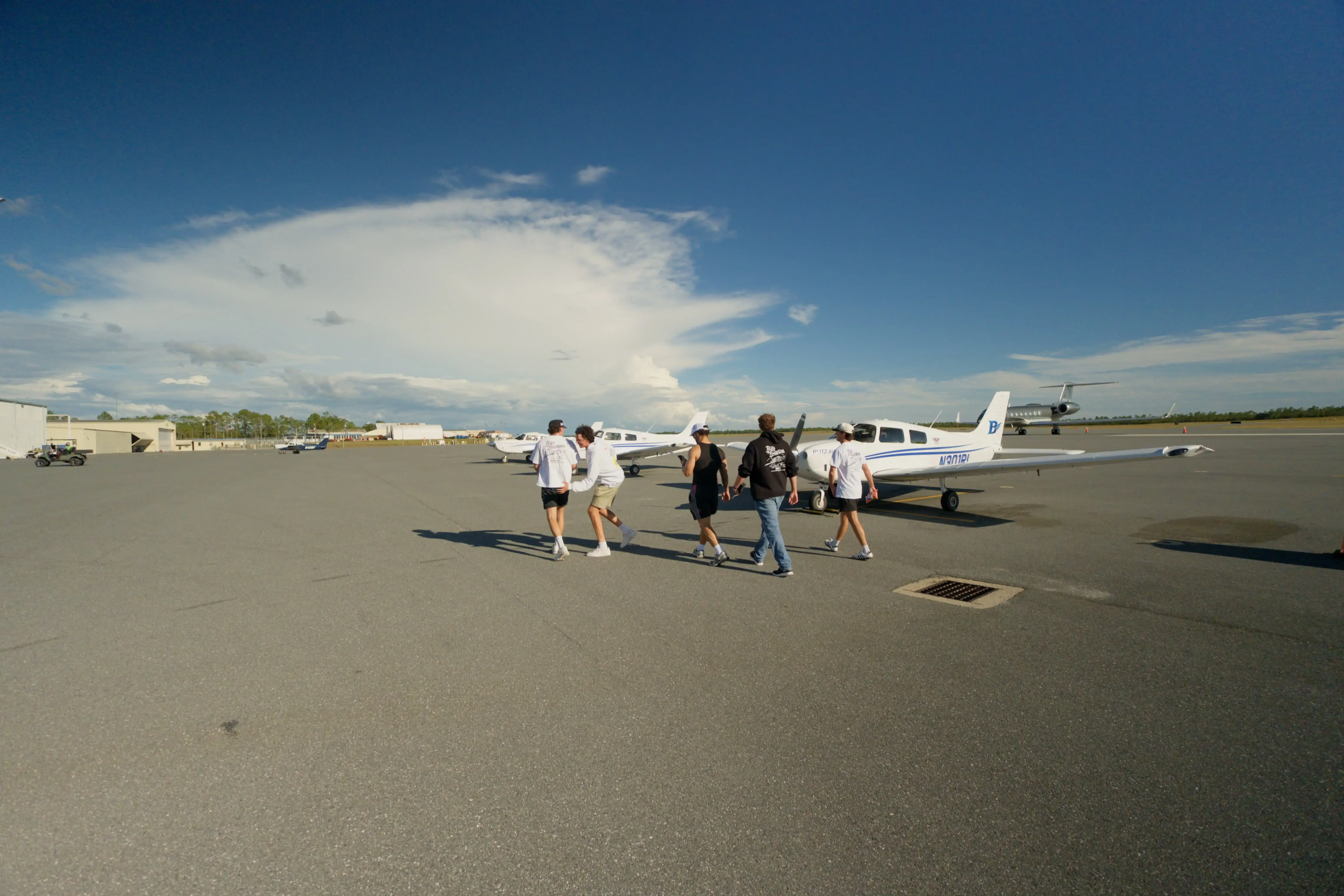 Blitz Aviation students walking across the ramp toward parked training planes at Ogden-Hinckley Airport