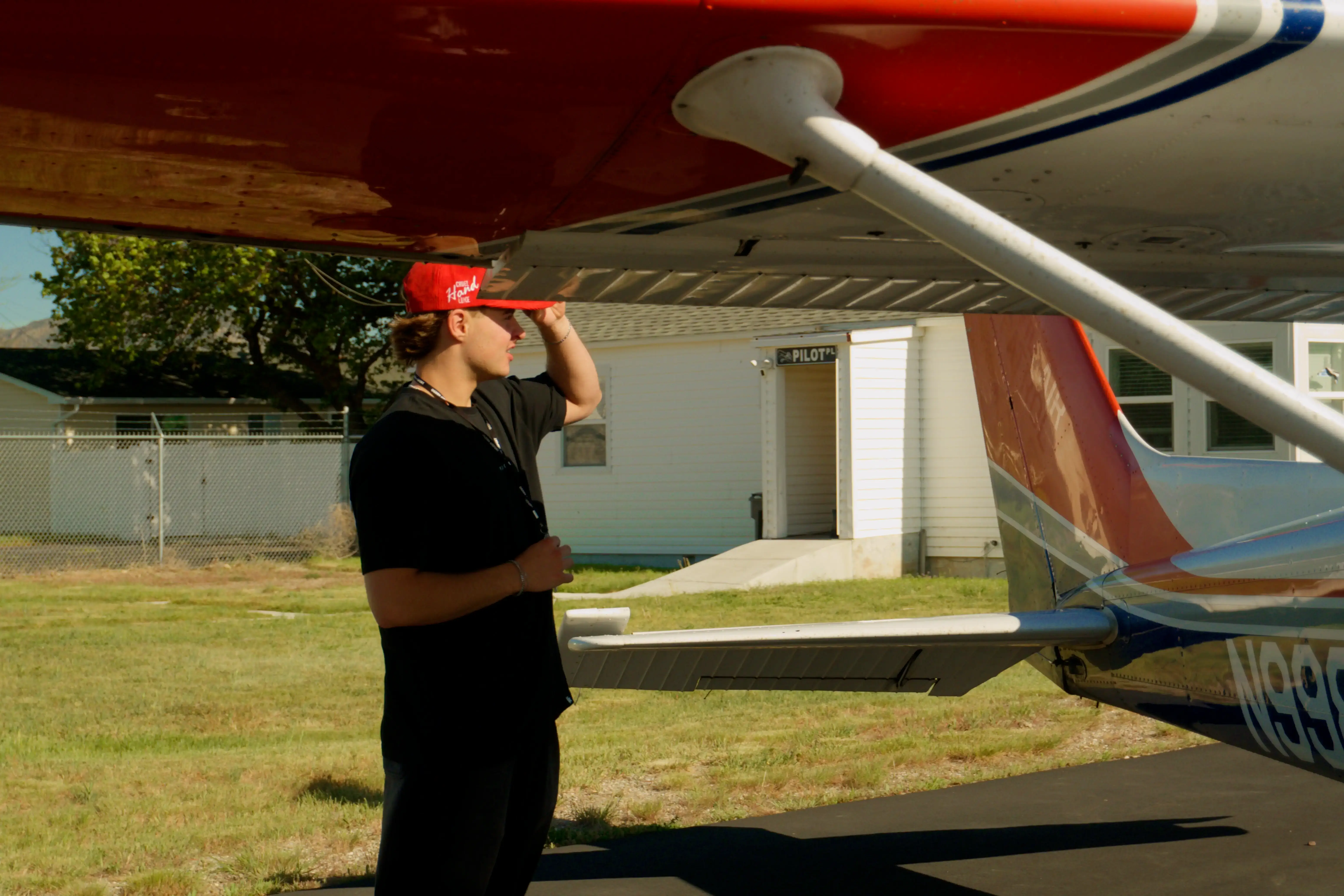 Woman with headset and sunglasses looking back at the camera while piloting an aircraft